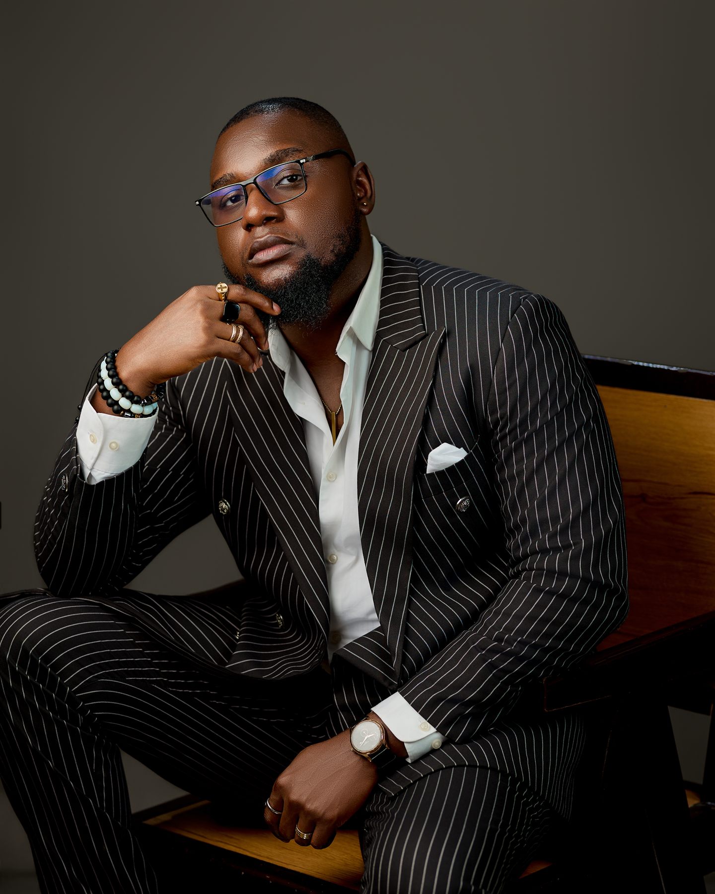 Levi Henry seated, in a pinstripe suit